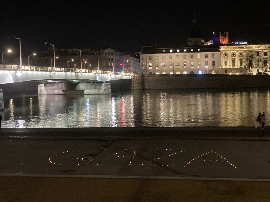 Photo d'un rassemblement aux bougies sur les quais de Lyon.
Le mot Gaza est écrit avec des bougies au sol. Derrière, on voit le Rhône, l'hôtel-dieu et Fourvière