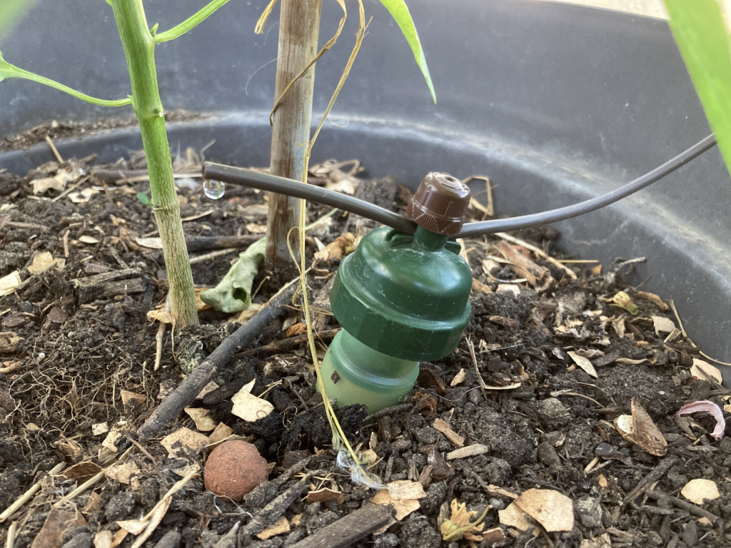 Photo d'un goutte-à-goutte vu de près, avec une goutte suspendue au bout du tuyau